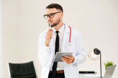 Hastanede tablet bilgisayar üzerinde çalışan doktor.