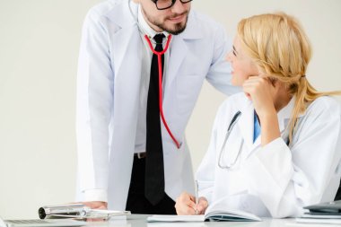 Doktor başka bir doktorla masada rapor yazıyor..