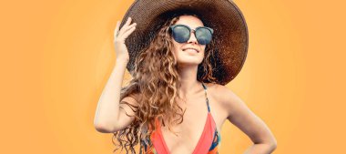 Renkli arka planda poz veren mayolu kadın.