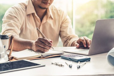 Masa başında çalışan genç mimar veya mühendis.