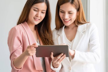 Ofiste tablet bilgisayar kullanan iş kadınları.