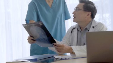 Doktor ve hemşire x-ray görüntü o ameliyat sonucu göstermek tartışmak