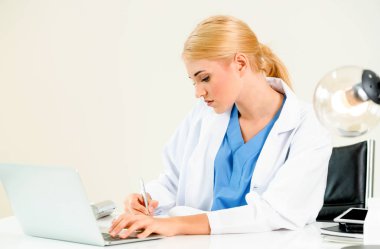 Hastanede tıbbi rapor üzerinde çalışan doktor.