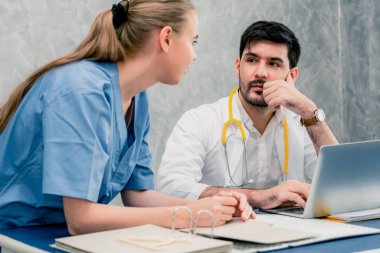 Dizüstü bilgisayarla çalışan doktor ve hemşire.