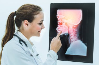 Doktor hasta başının x Ray filmi ile çalışıyor.