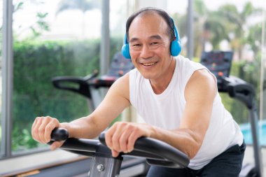 Fitness merkezinde bisiklet makinesi üzerinde Kıdemli adam egzersiz