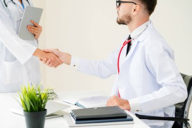 Hastanedeki doktor başka bir doktorla el sıkışıyor