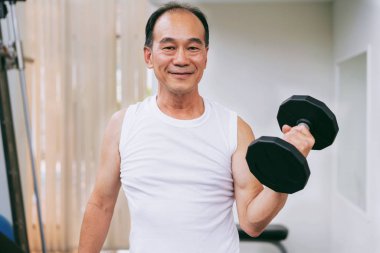 Fitness salonunda dumbbell kaldırma Kıdemli adam.