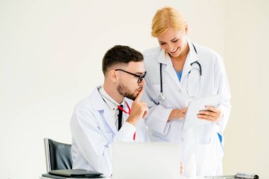 Hastanedeki doktor ortağıyla bilgisayar başında çalışıyor.