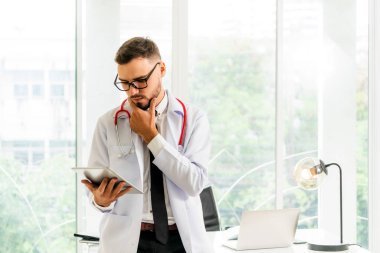 Hastanede tablet bilgisayar üzerinde çalışan doktor.