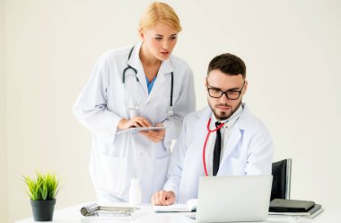 Hastanedeki doktor ortağıyla bilgisayar başında çalışıyor.