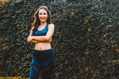 Genç spor kadını parkta sabah egzersizi yapıyor.