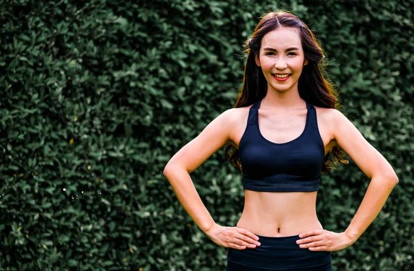 Genç spor kadını parkta sabah egzersizi yapıyor.