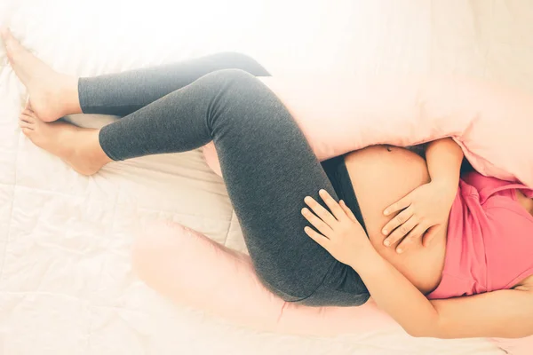 Mujer embarazada feliz durmiendo en la cama en el dormitorio. — Foto de Stock