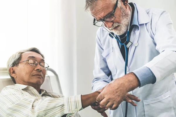 Volwassen arts en senior patiënt in ziekenhuis Ward. — Stockfoto