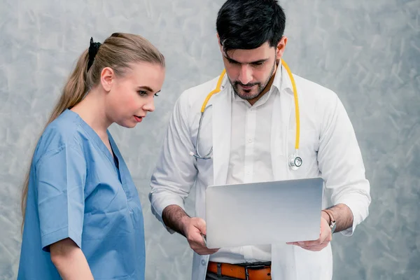 Médico y enfermera trabajando con computadora portátil . — Foto de Stock