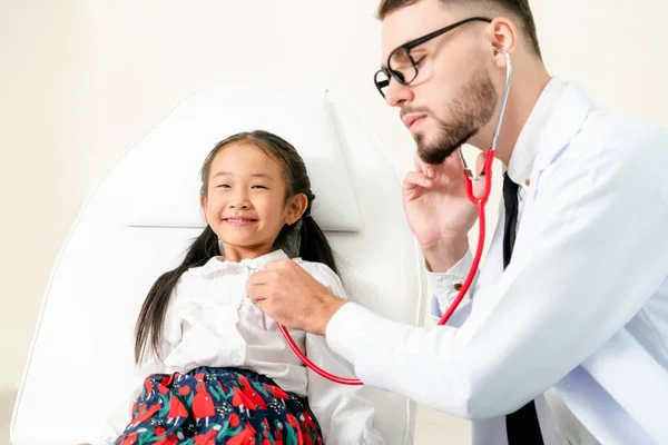 Médico examinando pequeño niño feliz en el hospital . — Foto de Stock