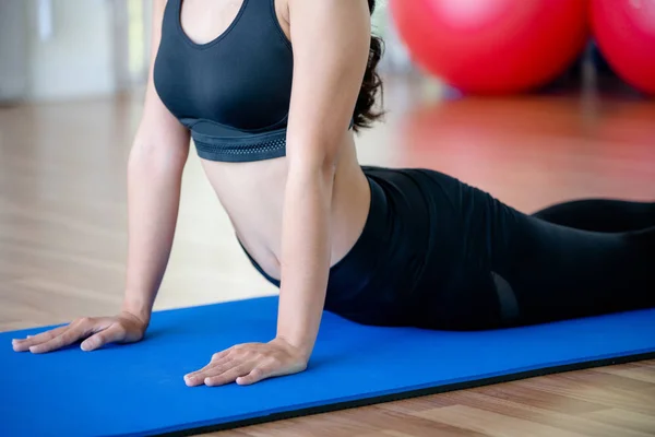 Mujer joven practica yoga en un estudio de gimnasia . —  Fotos de Stock