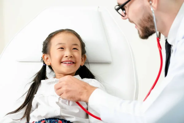 Médico examinando pequeño niño feliz en el hospital . — Foto de Stock