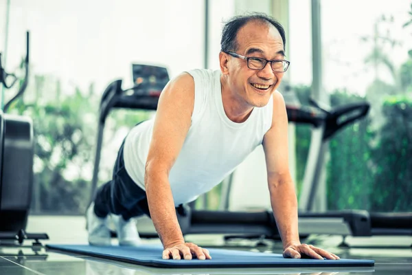 Uomo anziano spingere in palestra fitness . — Foto Stock