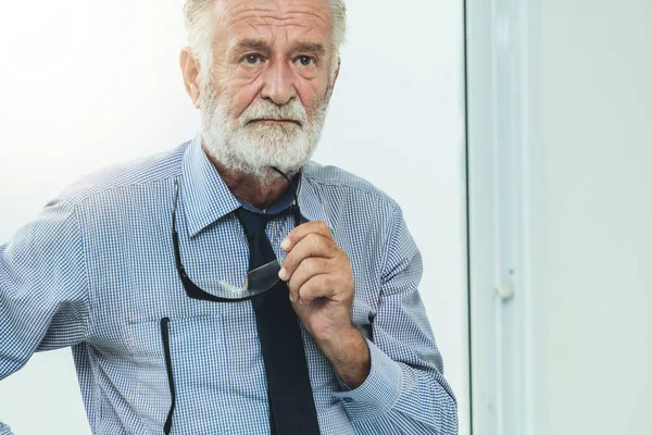 Senior man portret houden brillen in zijn hand. — Stockfoto