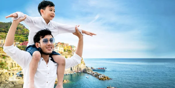 快乐的父亲在度假时把儿子扛在肩上. — 图库照片