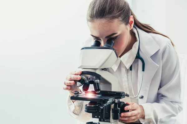 Doctor using microscope in hospital laboratory.