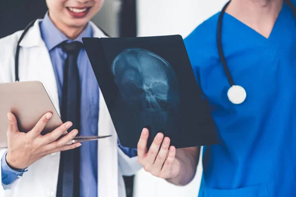 Médicos que trabajan con radiografías de la cabeza del paciente . — Foto de Stock