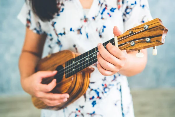 Mulher feliz músico tocando ukulele no estúdio . — Fotografia de Stock