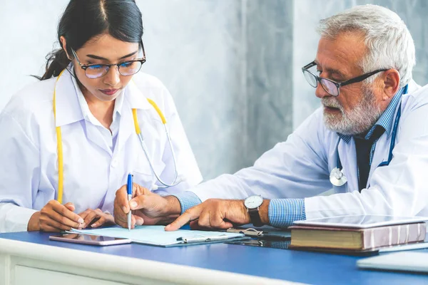 Médico senior masculino que trabaja con otro médico . — Foto de Stock