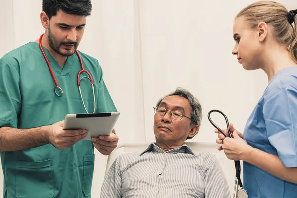 Équipe de médecins prenant soin d'un patient adulte âgé . — Photo