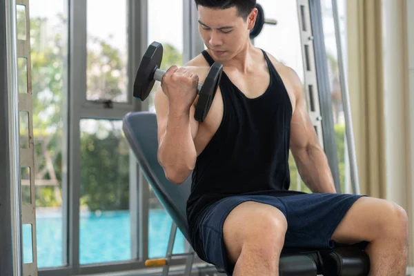 Gespierde man bodybuilder opleiding met halters. — Stockfoto