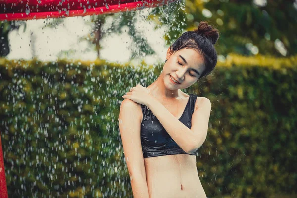 Frau duscht im Schwimmbad im Ferienort. — Stockfoto