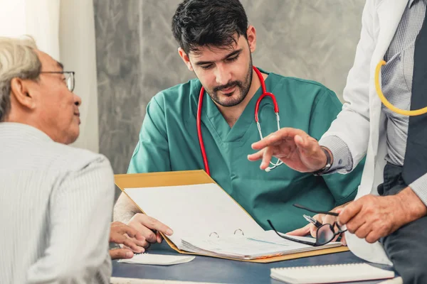 Equipe médica masculina conversando com a visita do paciente sênior — Fotografia de Stock