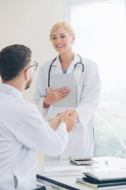 Hastanedeki doktor başka bir doktorla el sıkışıyor