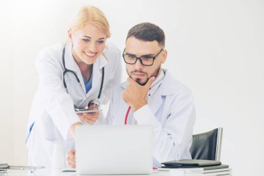 Hastanedeki doktor ortağıyla bilgisayar başında çalışıyor.