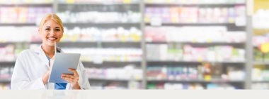 Eczanede tablet bilgisayar kullanan eczacı.