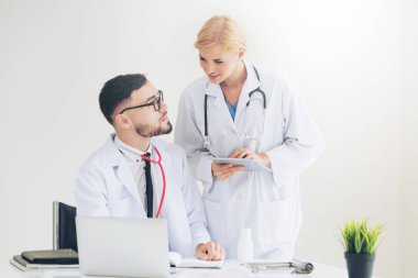 Hastanedeki doktor ortağıyla bilgisayar başında çalışıyor.