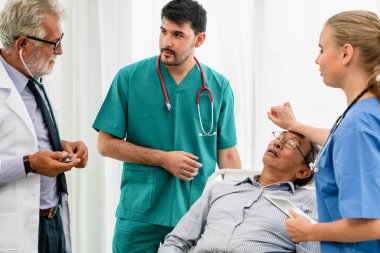 Doktor ekibi hastane koğuşunda yatan kıdemli yetişkin hastayla ilgileniyor. Tıbbi sağlık personeli hizmet tedavi konsepti.