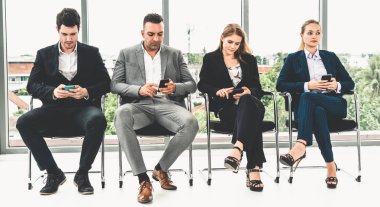 Cep telefonu kullanan iş kadınları ve işadamları.