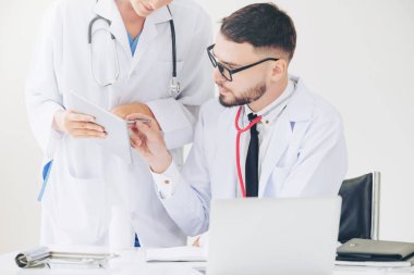Hastanedeki doktor ortağıyla bilgisayar başında çalışıyor.