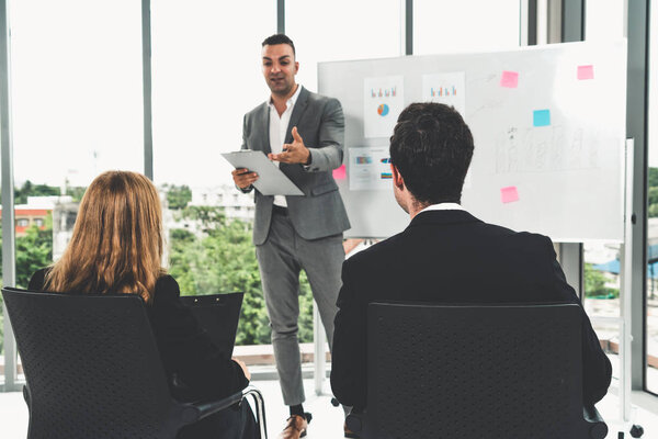 Businesswomen and businessmen in group meeting.