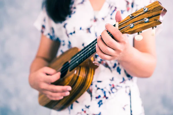 Mulher feliz músico tocando ukulele no estúdio . — Fotografia de Stock