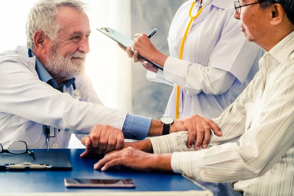 Senior arts praten met de patiënt in het ziekenhuis. — Stockfoto