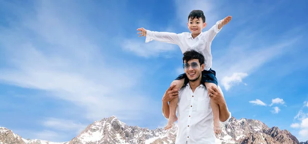 Šťastný otec nosí syna na ramenou na dovolené. — Stock fotografie