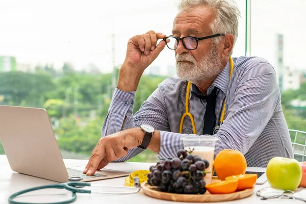 高级男性营养师医生在笔记本电脑上工作. — 图库照片