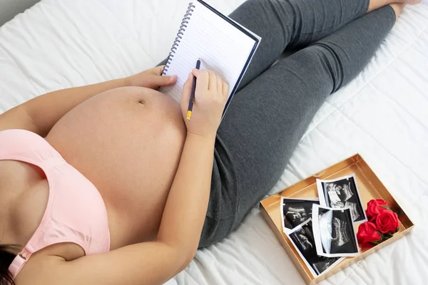 Mujer embarazada feliz y esperando un bebé en casa. — Foto de Stock