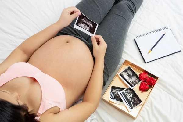 Mujer embarazada feliz y esperando un bebé en casa. — Foto de Stock