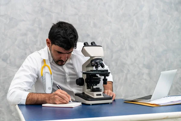 Hastane laboratuvarında mikroskop kullanan doktor. — Stok fotoğraf