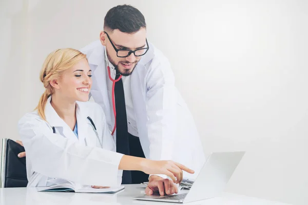 El médico en el hospital trabaja en el ordenador con el socio . — Foto de Stock